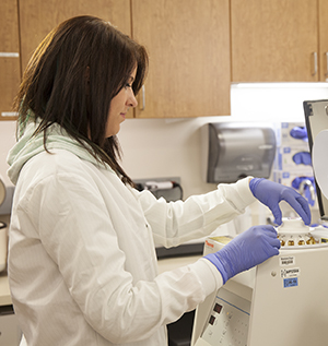 Lab tech with lab equipment and blood samples.